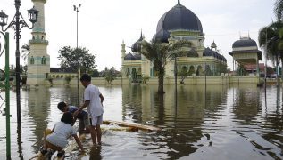 Indonesians climb over logs in walk to aid centre as flood deaths exceed 900