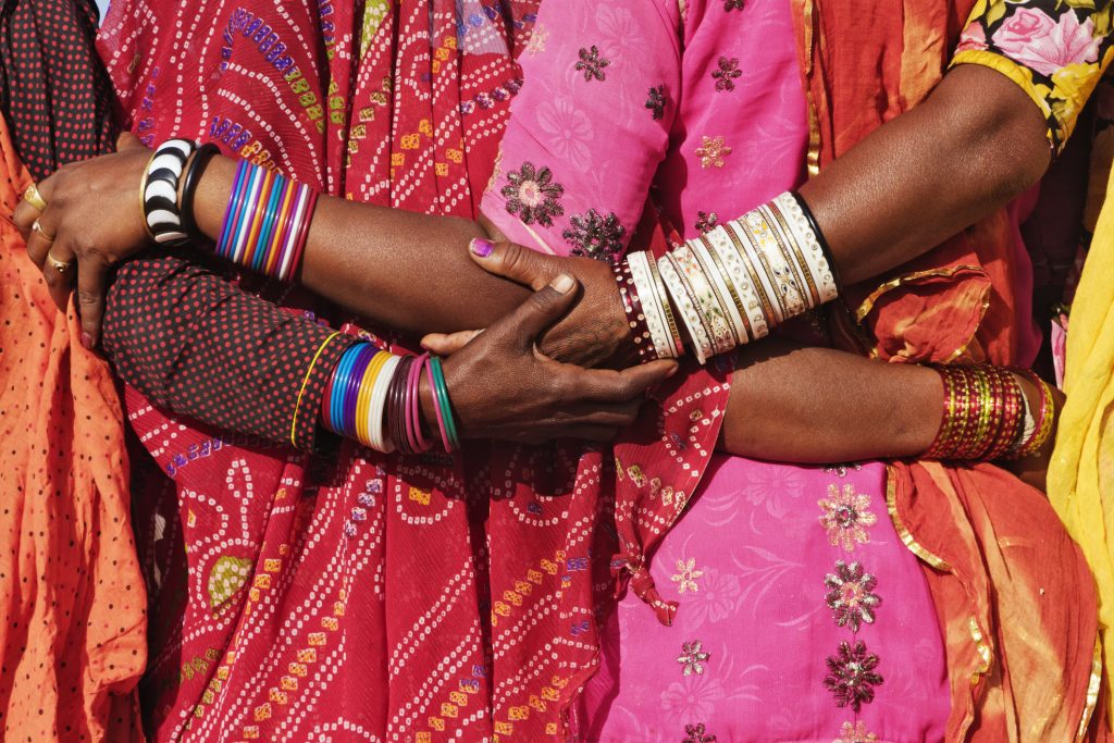 Women in traditional Indian clothing hugging